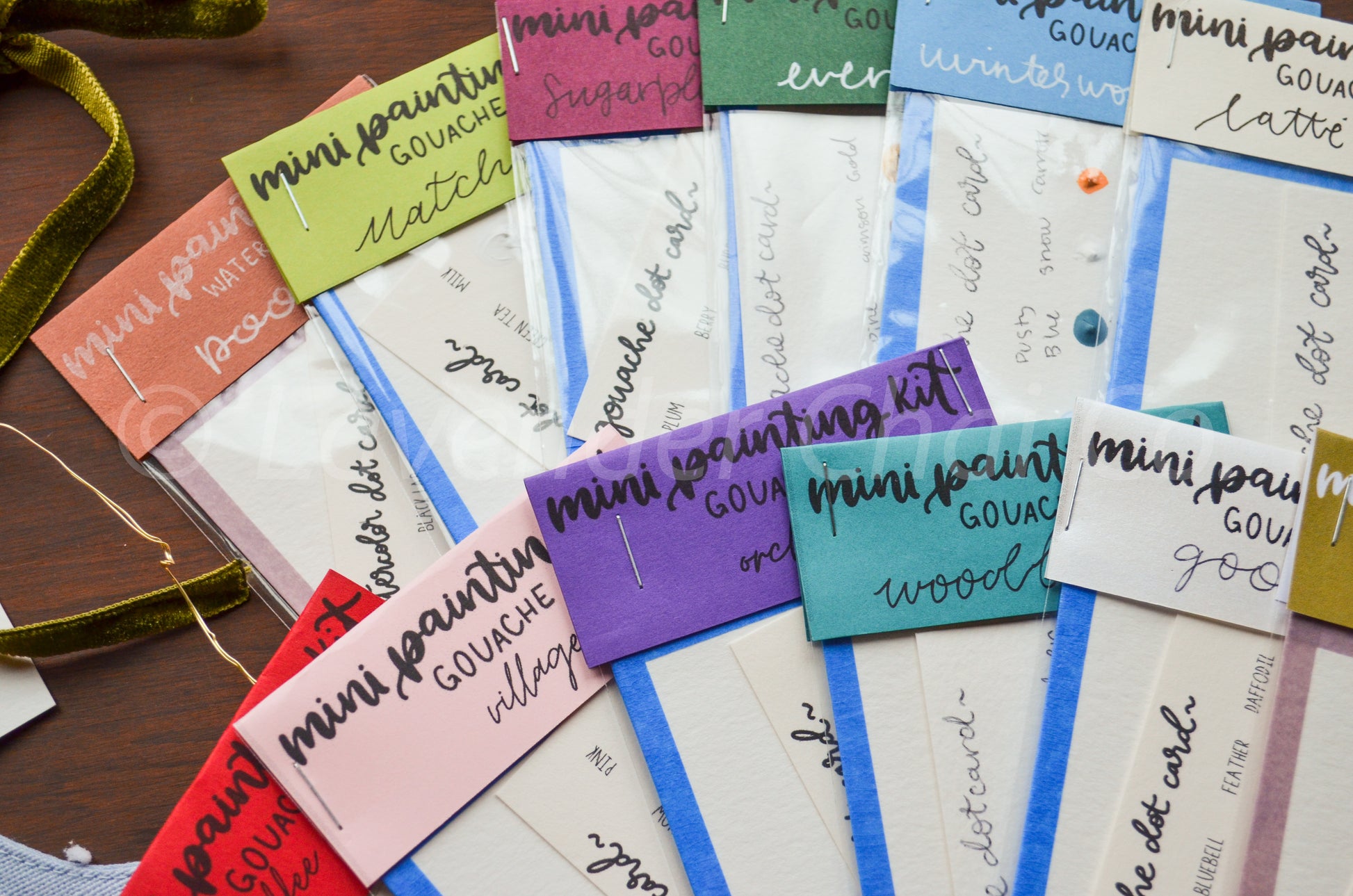 Collection of colorful paint kits with text on a wooden surface